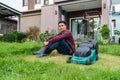 Man sitting with a lawn mower for cutting grass at home Royalty Free Stock Photo