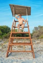 Man sitting on lifeguard tower. Royalty Free Stock Photo