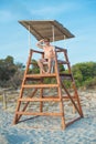 Man sitting on lifeguard tower. Royalty Free Stock Photo