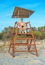 Man sitting on lifeguard tower. Royalty Free Stock Photo