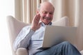 Man sitting in the living room and having videochat on the laptop computer