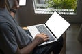 Man sitting in living room holding mobile phone and using laptop computer. Royalty Free Stock Photo