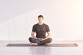Man sitting at lotus yoga pose. Home morning routine.