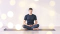 Man sitting at lotus yoga pose. Home morning routine.