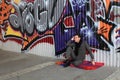 Man sitting near graffiti wall Royalty Free Stock Photo