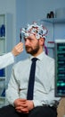 Man sitting on neurological chair with brainwave scanning headset