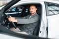 Man sitting in new car, showroom Royalty Free Stock Photo