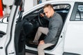 Man sitting in new car, showroom Royalty Free Stock Photo