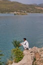 A man sitting next to the lake and enjoying the view