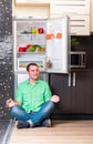 The man sitting next to open refrigerator Royalty Free Stock Photo