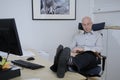 Man sitting in office and reading the newspaper Royalty Free Stock Photo