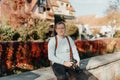 Man Sitting in Old European City And Holding Photo Camera. Contemporary Stylish Blogger And Photographer. Handsome man Royalty Free Stock Photo