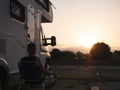 Man sitting outside his motor home watching the sunset Royalty Free Stock Photo