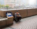 Elders cigarette vendor reads atop skywalk street overpass Shanghai China Wednesday, April 5, 2017