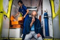 Man sitting with an oxygen mask in an ambulance car, a nurse looking for some supplies in her medical kit Royalty Free Stock Photo