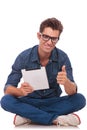 Man sitting with pad shows ok Royalty Free Stock Photo