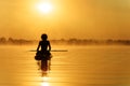 Man sitting on paddle board and enjoying amazing sunrise Royalty Free Stock Photo