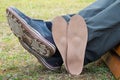 Man sitting on park bench with orthopedic insoles located near the legs.Healthy relax on nature. Outdoors Royalty Free Stock Photo