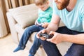 Man sitting and playing computer games with his little son Royalty Free Stock Photo