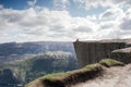 Man sitting on the Preikestolen, Pulpit Rock in beautiful Norway mountain landscape