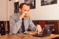 Man sitting in restaurant with laptop,and phone Royalty Free Stock Photo