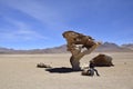 A man is sitting next to the famous stone tree rock formation (Arbol de Piedra) in the Siloli desert. Bolivia Royalty Free Stock Photo