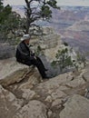 Man sitting on a Rock Overlooking the Grand Canyon