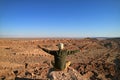 Man Sitting on the Rock Raising Arms Appreciating the Awesome view of the Moon Valley or Valle de la Luna