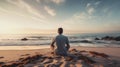 Man sitting on a sand beach and looking to the sea. Peaceful place to relax and meditate.