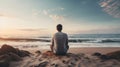 Man sitting on a sand beach and looking to the sea. Peaceful place to relax and meditate.