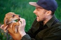 Man sitting screaming while ginger puppy biting him on finger Royalty Free Stock Photo