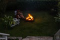 Man sitting by small fire in garden