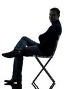 Man sitting smiling looking at camera silhouette full length Royalty Free Stock Photo