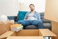 Young tired man after relocation surrounded by large boxes