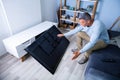 Man Sitting On Sofa In Front Fallen Television Royalty Free Stock Photo