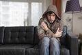 Man is sitting on sofa at home and feeling cold. Royalty Free Stock Photo