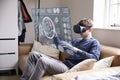 Man Sitting On Sofa At Home Wearing Virtual Reality Headset Royalty Free Stock Photo