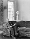 Man sitting on sofa and reading a book Royalty Free Stock Photo