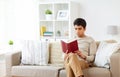 Man sitting on sofa and reading book at home Royalty Free Stock Photo