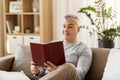 Man sitting on sofa and reading book at home Royalty Free Stock Photo