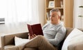 Man sitting on sofa and reading book at home Royalty Free Stock Photo