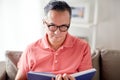 Man sitting on sofa and reading book at home Royalty Free Stock Photo