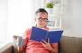 Man sitting on sofa and reading book at home Royalty Free Stock Photo