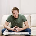 Man sitting on sofa reading newspaper