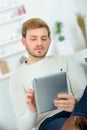 man sitting in sofa using electronic tablet Royalty Free Stock Photo