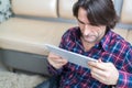 Man sitting in sofa using electronic tablet Royalty Free Stock Photo