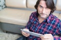 Man sitting in sofa using electronic tablet Royalty Free Stock Photo