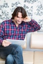 Man sitting in sofa using electronic tablet Royalty Free Stock Photo