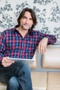 Man sitting in sofa using electronic tablet Royalty Free Stock Photo