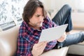 Man sitting in sofa using electronic tablet Royalty Free Stock Photo